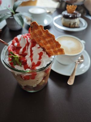 Erdbeerbecher mit Grießbrei-, Milchreis- und Schokoeis, und Cappucino at Eisdiele Frohnatur in Kassel