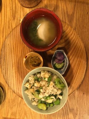 A wholesome rice dish featuring beans and parsley, paired with homemade sesame salt, miso soup, and a selection of traditional Japanese pickles. at Chakura in Sakaishi