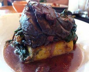 Portobello Steak with Polenta and Greens: Marinated, roasted portobello mushrooms with rosemary polenta, braised greens, and red wine mushroom sauce. at Portobello Vegan Trattoria in Portland
