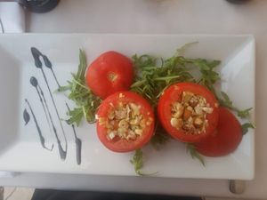 Uncooked dish of stuffed tomatoes with vegetables, nuts, and lettuce. at Hotel Piran in Piran