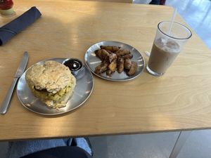 Sausage egg and cheese biscuit, home fries, iced latte 💗  at Project Coffee - Burns Court in Sarasota