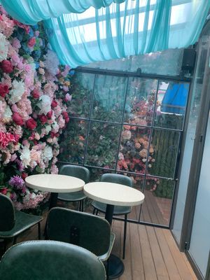 Seating behind the espresso bar with really aesthetic floral wall at Lucky Tea in Seoul