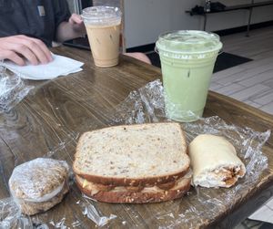 Left to right: oatmeal whoopie pie, bbq tempeh sandwich, pepperoni roll, Fairy Brew matcha lattee  at Quantum Bean Coffee in Morgantown