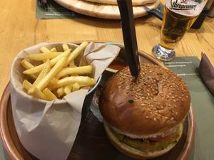 Vegan patty in a sesame seed burger bun with hemp pesto and salad, served with french fries and a bbq tomato sauce at Hedonist in Zadar