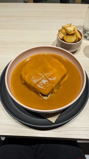 Francesinha with seasoned fries at Kind Kitchen in Porto