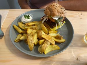 Crispy seitan & bacon (pão de hambúrguer de fermentação lenta, panado de seitan, bacon, fatia de queijo, pickles de pepino, tomate, salada coleslaw, maionese e ketchup) - 13€ at Kind Kitchen in Porto