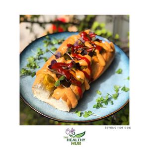 Vegan hot dog with BEYOND MEAT sausage, The Fermented Kitchen sauerkraut, chipotle mayo, jalapeño and microgreens. at The Healthy Hub Cafe in Cairns