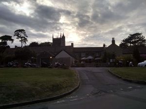 External of pub with church in background at Ring O' Bells in Paulton