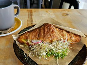 Savory croissant with sausage, cheese sauce, and a lot of sprouts at Rohe in Tallinn