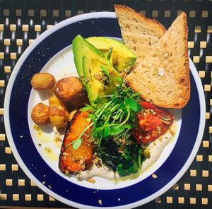 Our special VEGAN BREAKFAST with spinash, Grilled tomato, Avocado, Pumkin, Bread, all of this on a bed of homemade cashew cheese. at Cremat 11 in Barcelona