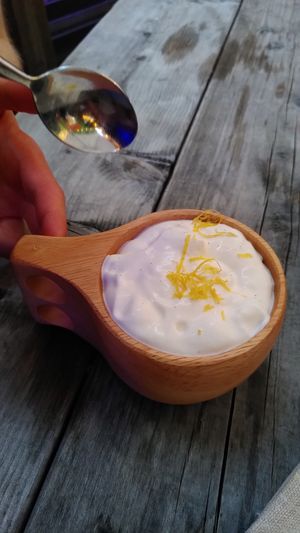Yummy vegan plum desert with caramelised sugar, crisp and whipped cream and lemon cest on top - served in a traditional wooden cup. at Jazzköket in Ostersund