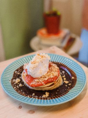 Panqueca com coulis de framboesa, crumble de cookie, calda de cacau, banana e chantilly  at Soul - Alimentação Saudável e do Bem in Braga