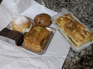 Izq>der: Brownie, bomba crema, napolitana de pistacho, doowap y focaccia de hummus, rúcula y pimientos del piquillo at Dolce Capriccio Pasticceria in Oviedo