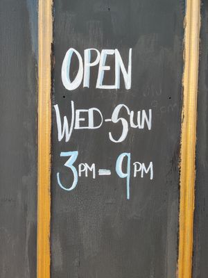 Opening hours painted on the entrance door at Earth's Kitchen  in Birmingham