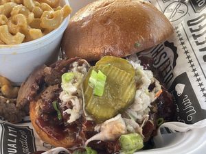 Titus Town Veef™ Brisket with slaw, valdalia VBQ Sauce and B&B Pickles at Grass VBQ Joint - Cloud Kitchen in Decatur