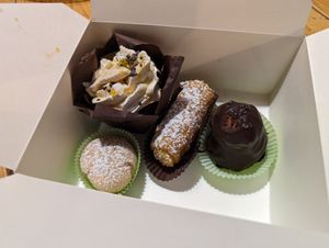 Box of incredible treats. Brownie with panna, creme filled doughnut, vanilla roll, delicious chocolate tower thing I forget the name of. at Leccornie in Milan