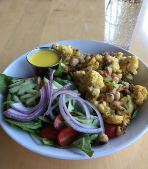 Cauliflower Shawarma Bowl (vegan as is). Roasted cauliflower, chickpeas, warm quinoa, tomato, cucumber, onion, turmeric dressing. Good. Recommended for those who like cauliflower. at Peoples Organic in Eden Prairie