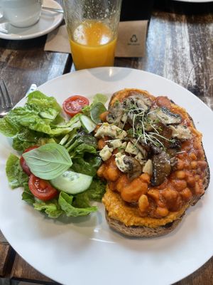 White beans on sourdough with hummus, mushrooms, vegan feta and a side salad  at Café Nullpunkt in Berlin