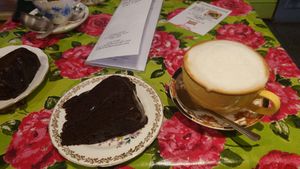 Vegan chocolate cake (from specials board) and cappuccino with alpro barista oat milk at Shakespaw Cat Cafe in Stratford-upon-avon