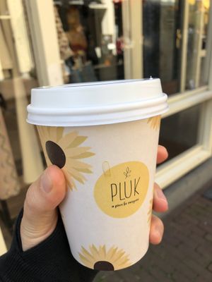 Delicious soy matcha latte in a cute cup 🌻  at Pluk in Amsterdam