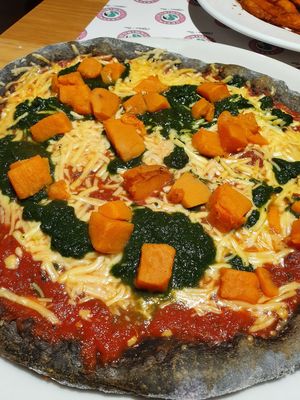 Halloween pizza from October, with spinach, cheese, tomato sauce, sweet potato and black dough at Green Flamingo in Innsbruck