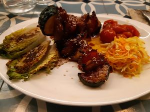 Main: Heura brand plant-based chicken brochette with roasted vegetables at VEGA - Alamo in Madrid