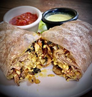 “Breakfast Burrito” 
tofu scramble, potatoes, black beans, tempeh bacon, provolone, mushrooms, onions. Served with red salsa and cilantro dressing on a whole wheat tortilla  at SunCafe in Studio City