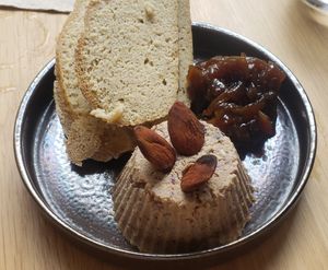 Soya "cheese" with olives and herbs, served with homemade bread and confit d'oignons at Xuxu in Biarritz