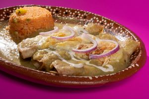 Enchiladas suizas tortilla stuffed Witherspoon vegetable chiken breast made With green sause and red rice. at Veggicano Plant Based in Mexico City