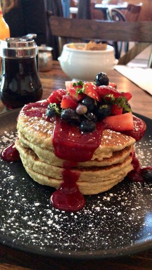 Apple-almond oat pancakes with berry sauce and fresh mixed berries at Petisco Vegano in New York City