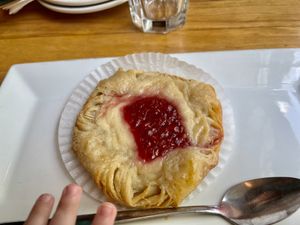 Baby hand trying to sneak my delicious danish!! at Watercourse Foods in Denver