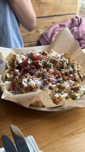 nachos - tortilla chips, cauliflower chorizo, cheese sauce, refried beans, pico de gallo, jalapeño aioli and cilantro   at Watercourse Foods in Denver