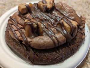 Chocolate cookie with chocolate frosting, peanut butter chunks, and Carmel and chocolate drizzle at Watercourse Foods in Denver