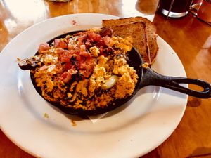 Tofu scramble, mushrooms, onions, tomatoes on homemade fries, with vegan cheese sauce and toast.  at Watercourse Foods in Denver