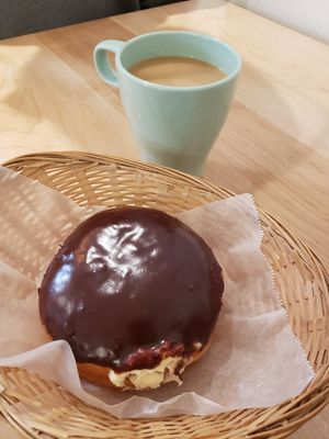 Delicious Boston cream donut with a cup of coffee at bloomer's in Toronto