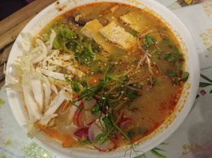 Tom yum soup with tofu, greens, noodles, cabbage and other vegetables at Dobrá Cajovna in Kutna Hora