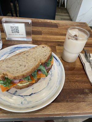 Sándwich de pan de masa madre: humus de garbanzos con encurtidos y kale + iced chai latte con leche almendra  at The Fix Specialty Coffee in Madrid