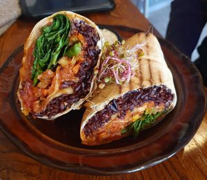 SPOT wrap with black rice, our homemade kimchi, marinated tofu, avocado, tomato, fresh spinach, and soy mayo at Avocado Spot in Gdansk