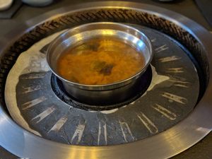 Soup pot in the middle, and around the sides is a griddle for frying ingredients at Monsoon Shabu Shabu in Hobart