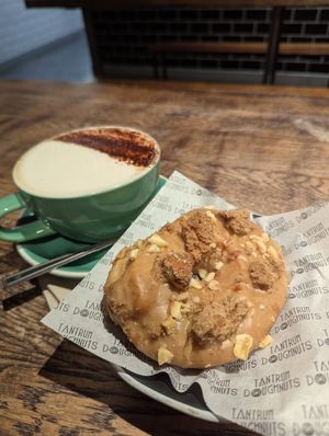 Banana Foster ring doughnut and oat cappuccino at Tantrum Doughnuts in Glasgow