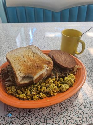 Vegan classic with sourdough toast, veggie sausage, hash browns, and the tofu scram. Coffee with oatmilk in the background. at Hartland Diner  in Hartland