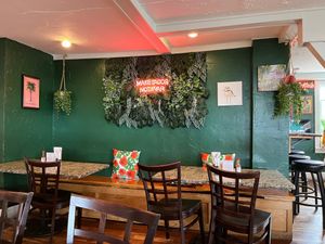 Interior dining area, neon sign says MAKE TACOS NOT WAR at Treehouse Taqueria in Ogunquit