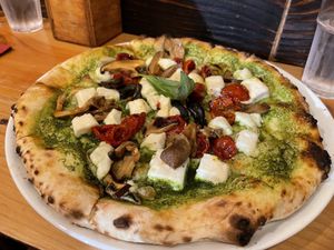 Vegan pizza with pesto, vegan cheese, dry tomatoes and mushrooms.  at Cheese & Tomatin in Inverness