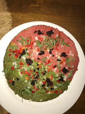 Raw pizza, half marinara and half pesto  at Peacefood Cafe - Uptown in New York City