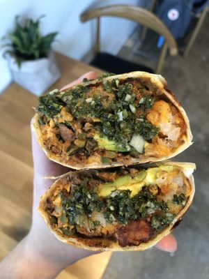 super delicious vegan breakfast burrito (not on menu but available so ask about it) with soyrizo, JUST egg, tots, chimichurri, and more! comes with fresh salsa and lime  at Coffee Parlor in Long Beach