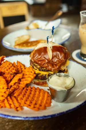 Single Speed Black Bean Burger - 
cashew black bean patties, violife cheddar, tomato, red onion, pickles, garlic mustard, pretzel bun, served with choice of friets at Centraal Grand Café and Tappery in Milwaukee