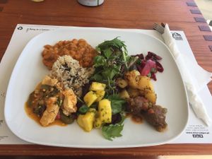 Platter of a soy meatballs with patatas bravas, tofu maqueca and beans and vegan sausage with rosemary (with rice and a salad). at M Butterfly by Miss Saigon in Lisbon