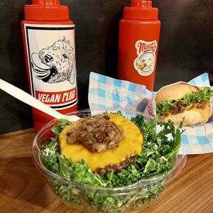 Kale salad with added Impossible vegan cheeseburger patty. Behind: Impossible cheeseburger  at Monty's Good Burger - Echo Park in Los Angeles