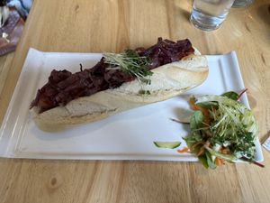 Goji hot dog with baguette, onion, gherkin, mustard, ketchup, tofu dog, etc. Comes with a small salad. Delicious and filling.   at Goji Vegetarian Cafe and Deli in York