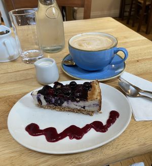 Vegan blackcurrant cheesecake & oatmilk lattee  at Goji Vegetarian Cafe and Deli in York